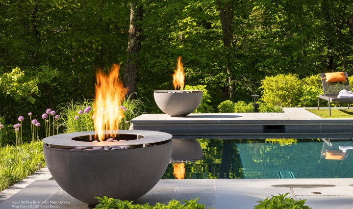 Hemi 36 fire bowl with metal drinks ring beside a contemporary outdoor swimming pool surrounded by woodland.